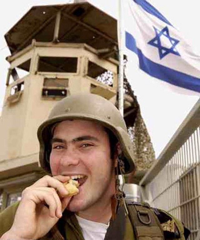 Israelsk soldat nyter å tygge på en øre-kake.