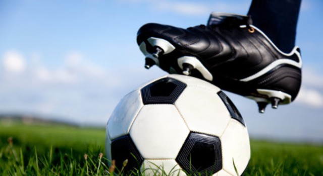 Football or soccer ball at the kickoff of a game - outdoors