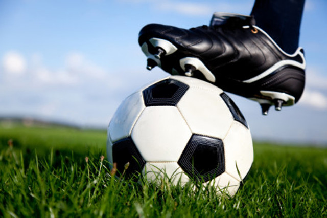 Football or soccer ball at the kickoff of a game - outdoors