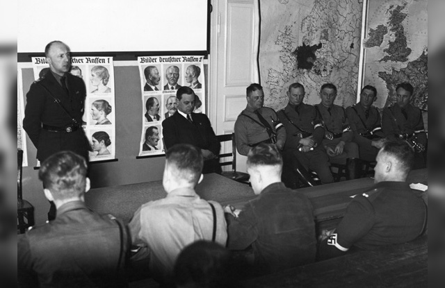 Helmut Stellrecht, til venstre, taler til ledere i Hitlerjugend. Ved siden av ham til høyre sitter Alfred Rosenberg.